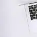 Free Aerial view of a sleek laptop keyboard on a clean, white surface, ideal for tech backgrounds. Stock Photo